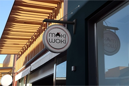 Enseigne du restaurant Moki Woki, restaurant de woks et mochi à emporter, montrant le logo de l'enseigne avec une illustration de geisha.